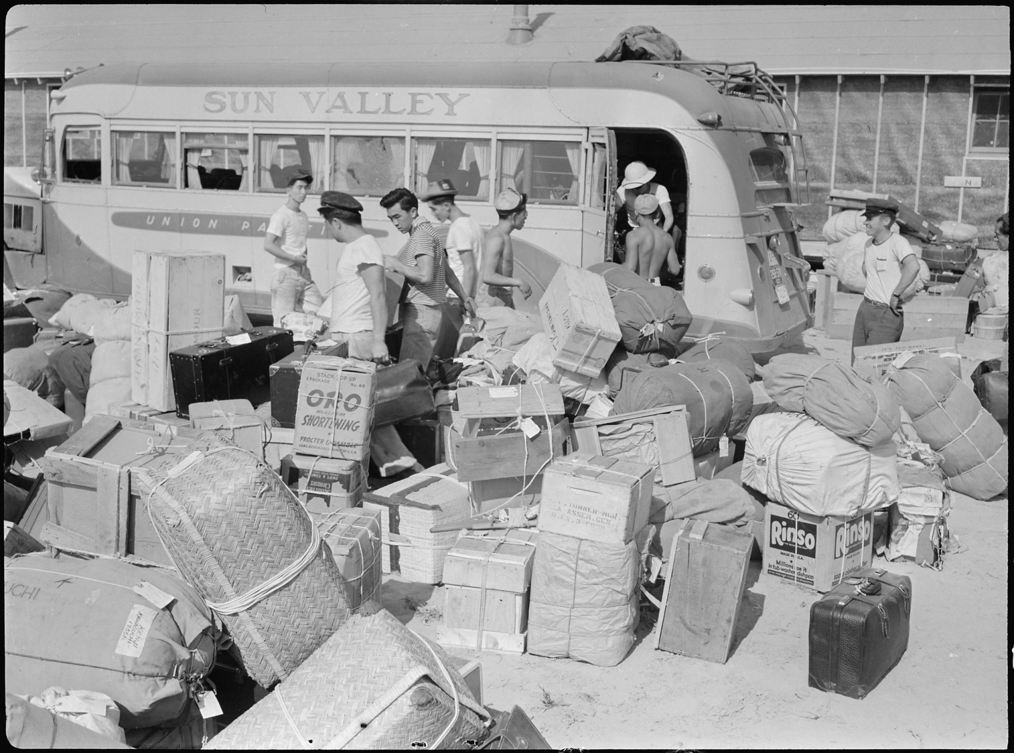 アイダホ州ミニドカ強制収容所に到着した日系人と衣類などの荷物（1942年8月17日）。写真:Francis Stewart from National Archives