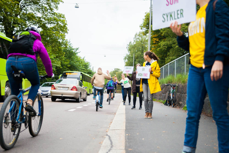 7:30に通勤する自転車乗りに朝の挨拶。ハイファイブ運動は緑の環境党だけがしているPR手段 Photo:Asaki Abumi