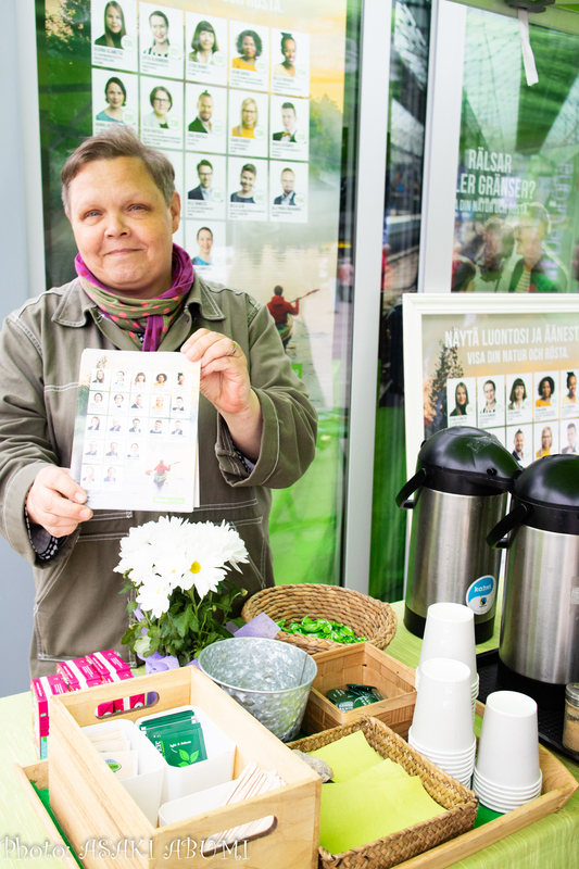 【フィンランド】選挙中に通りのスタンドでコーヒーやジュースを無料配布する緑の党。ボランティアの女性が手にしているのは選挙人名簿　撮影：あぶみあさき