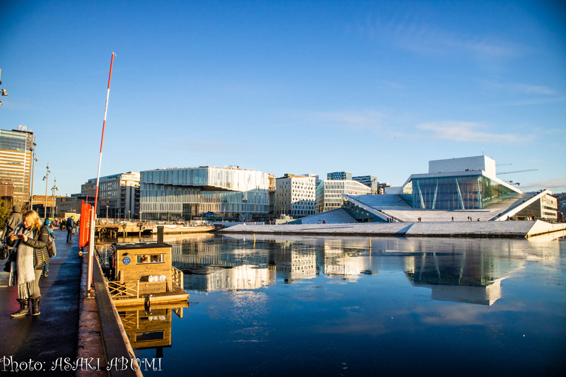 市民が横切る水上サウナ「KOK Oslo」（左側）、中央奥は公共図書館、右奥はオペラハウス。撮影日2019年1月　撮影：あぶみあさき