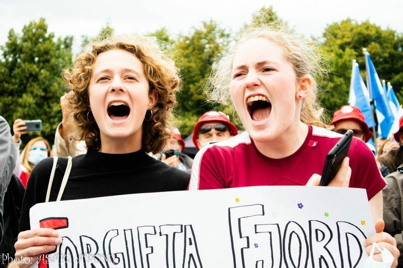 「フィヨルド汚染＝地球はどうでもいい」という抗議文で叫ぶ女性
