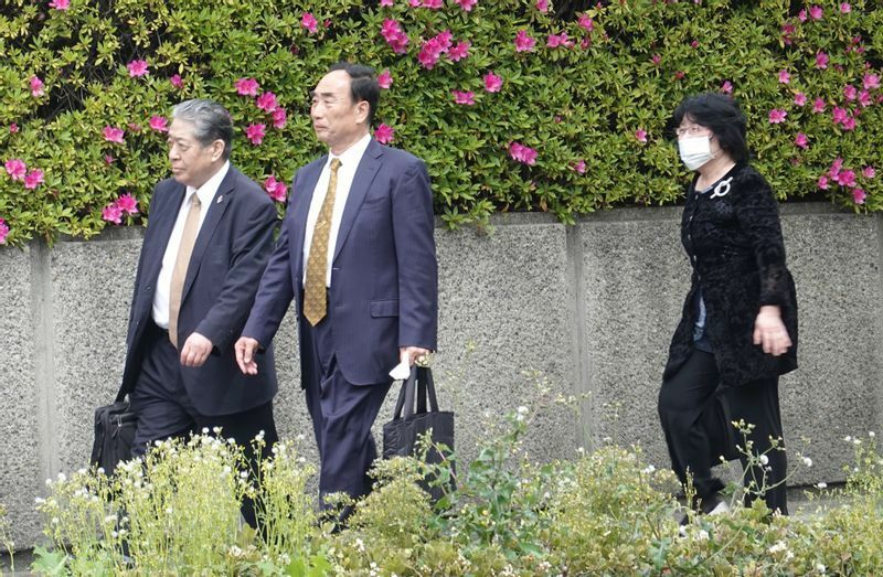 2022年4月18日、控訴審判決期日に臨むため大阪高等裁判所に入る籠池泰典被告、諄子被告と南出喜久治弁護士（筆者撮影）