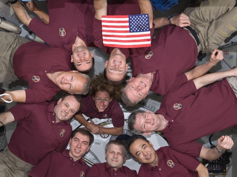 2011年のスペースシャトル最終ミッションでISSに持ち込まれた星条旗とクリス・ファーガソン宇宙飛行士の隣にダグ・ハーリー宇宙飛行士。右下はJAXAの古川聡宇宙飛行士。Credit: NASA