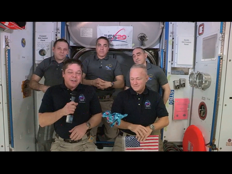 ボブ・ベンケン宇宙飛行士（前列左）、ダグ・ハーレー宇宙飛行士（前列右）の帰還セレモニー。ハーレー宇宙飛行士は、スペースシャトル最後のフライトで残された星条旗を手にしている。出典：NASA TV中継より