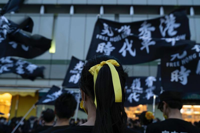 民主派のシンボルカラーの黄色のリボンをつけるデモ参加者（撮影 チンイシン）