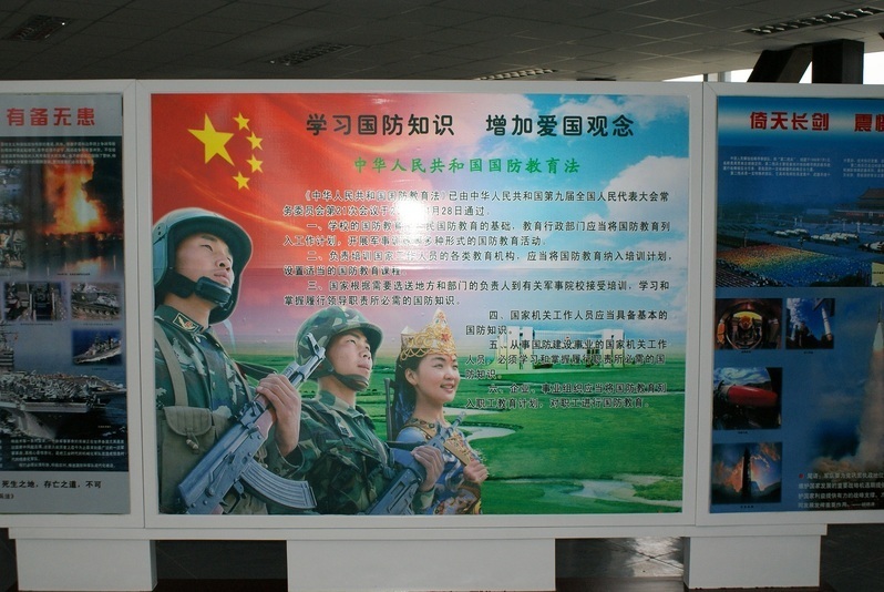 民族衣装の女性と解放軍兵士が並ぶ愛国ポスター