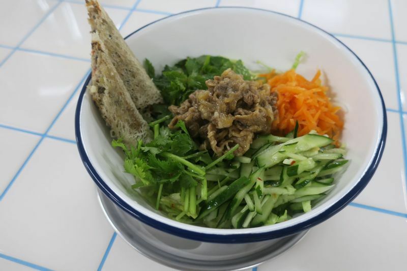 たっぷりのトッピングと平らな米麺をよく混ぜて食べる「感動ボブン」990円。（筆者撮影）