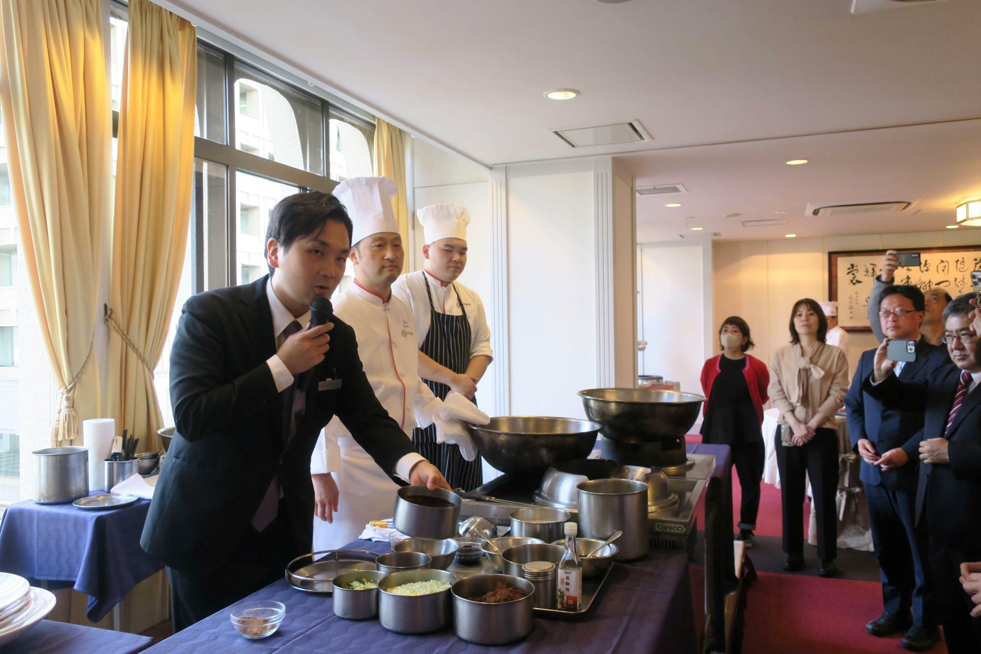 もう一人の主役、福本晋さんは「陳麻婆豆腐」の調理の仕方を赤坂四川飯店料理長の田中良治さんとの掛け合いで解説した（筆者撮影）