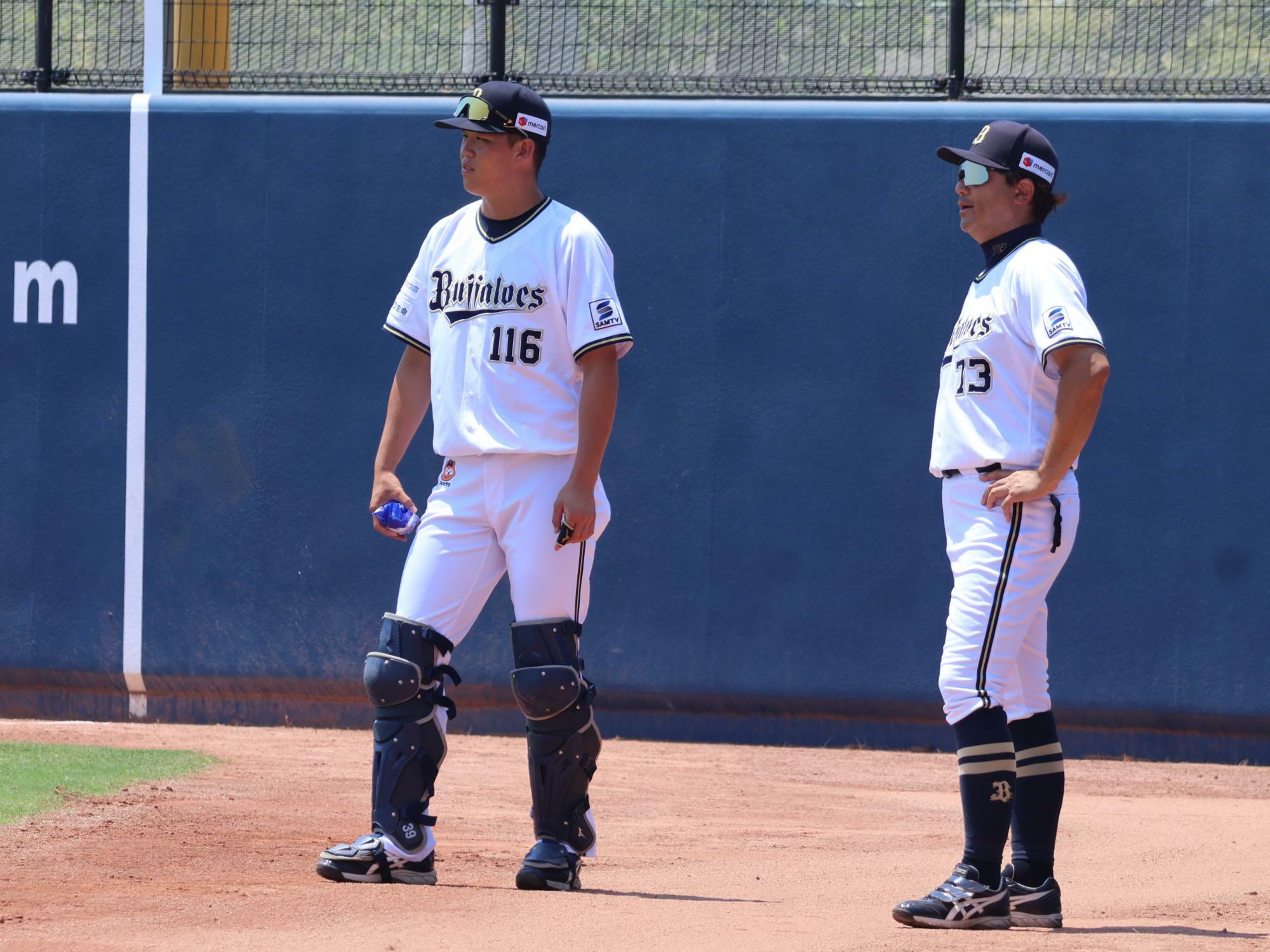 試合直前、牧野塁ピッチングコーチ（右）と先発投手のキャッチボールを見ている