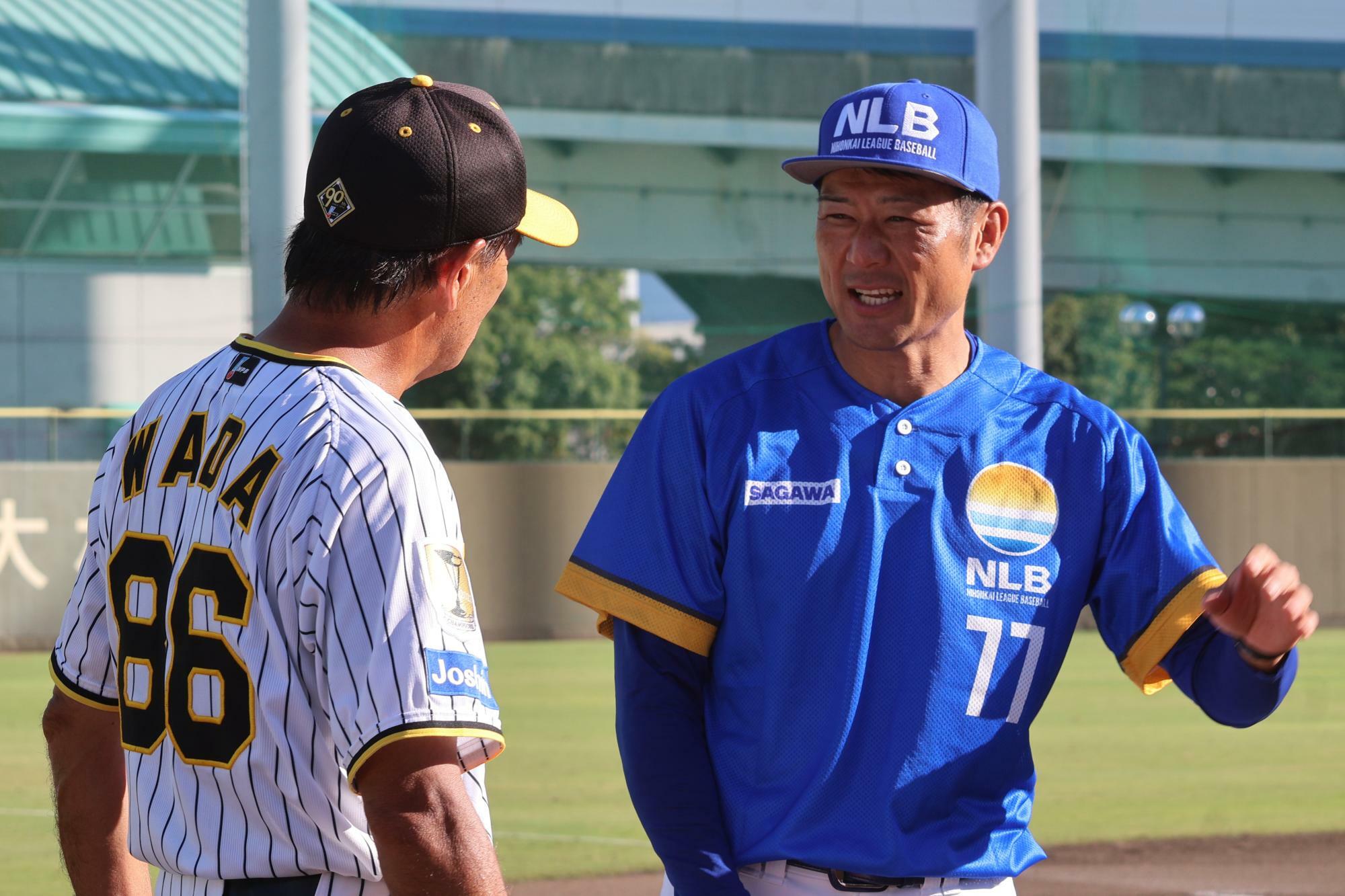 試合後、タイガースの和田豊ファーム監督と談笑する岡﨑太一監督（右）