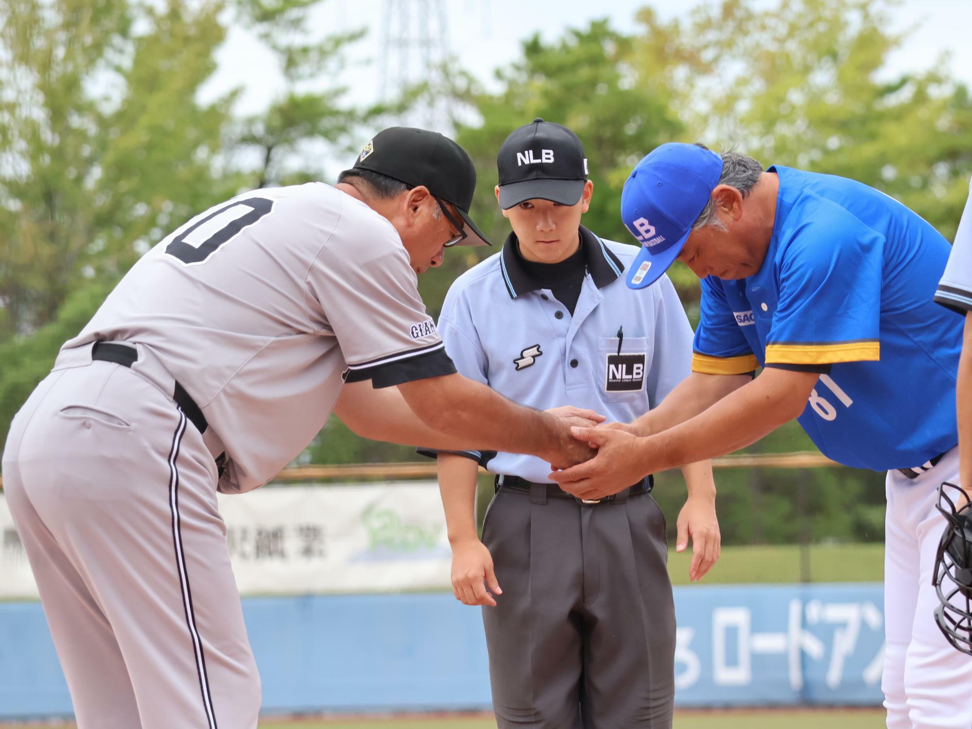 メンバー交換後、読売ジャイアンツ３軍の駒田徳広監督（左）と握手をする富山の吉岡雄二監督