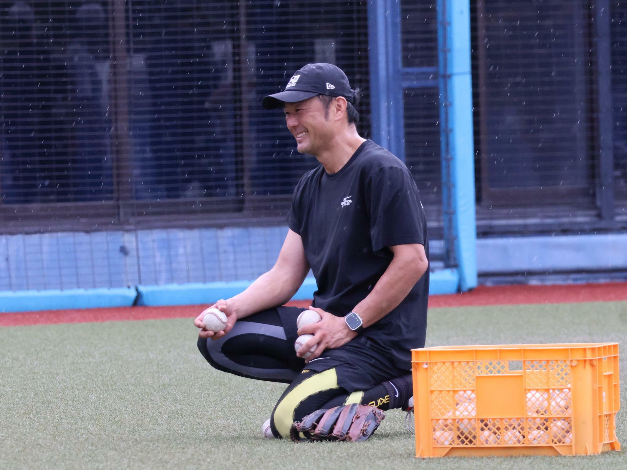 練習中、笑顔を見せる岡崎太一監督（石川）