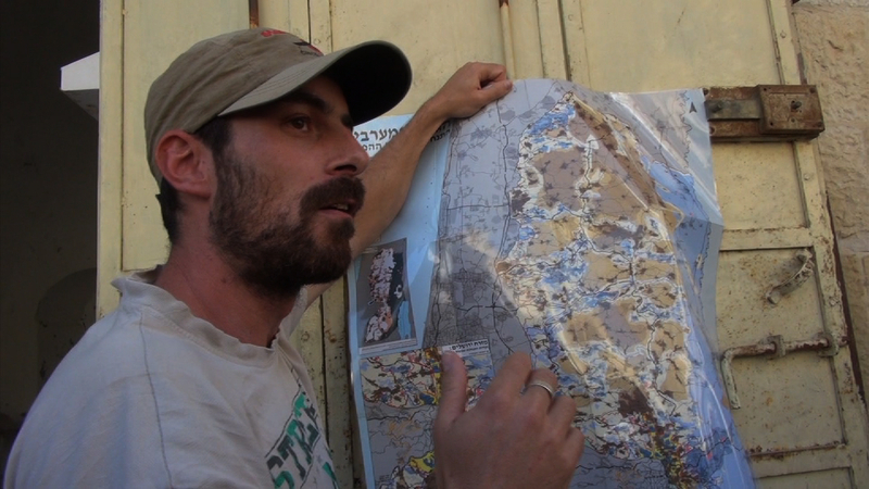ヨルダン川西岸の状況を地図で表示しながら、説明する「沈黙を破る」スタッフ、イド・イブンパズ