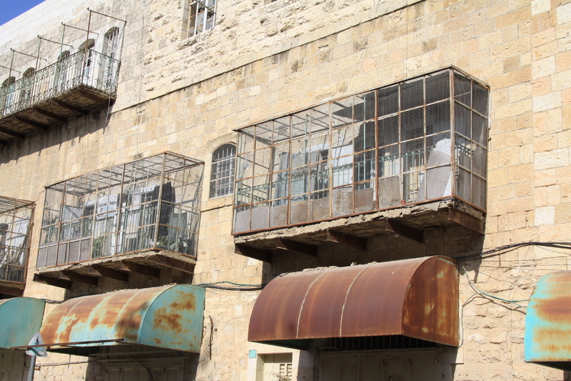 ユダヤ人入植者の投石や侵入を防ぐために、パレスチナ人の家のバルコニーは金網で覆われている。