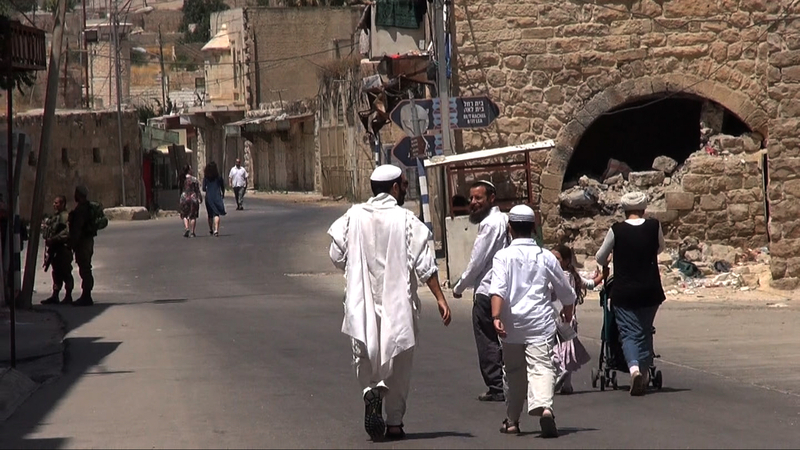 パレスチナ人が通行を禁じられているシュハダ通りを、入植者たちは自由に往来できる。ここはかつてパレスチナ人住民でごったがえする市場だった。