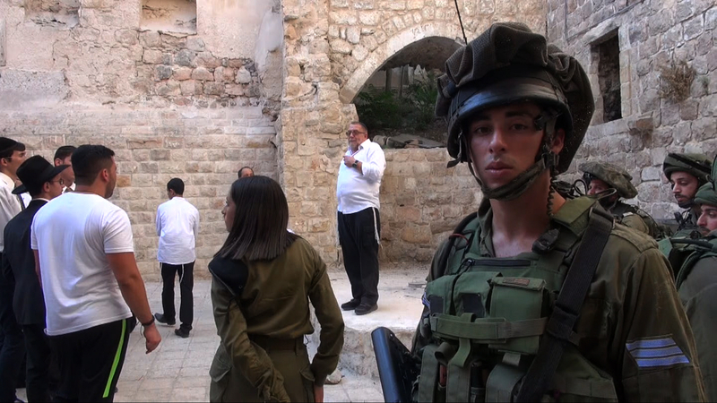 入植者の旧市街ツアーを警備するイスラエル兵。