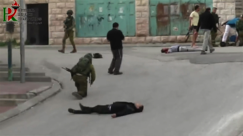 イマードが撮影した処刑直前の現場。倒れている手前の青年がこの直後に処刑された。（撮影：イマード・アブシャムシーエ））
