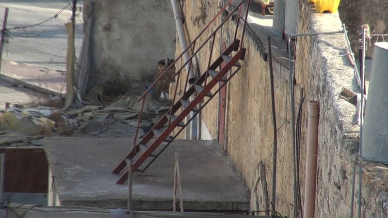 通りの入口を塞がれた住民は、隣人の家の2階から階段を使って自宅の屋上に上がり、家に出入りしなければならない。