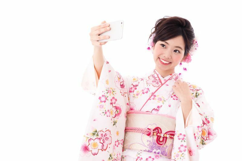 スマホを持ちながら着物でオンラインで参加という新成人も（takayuki/Shutterstock.com）