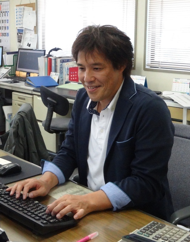 会社事務所での鈴木さん。社長室はなく、他の社員と机を並べて仕事をする。