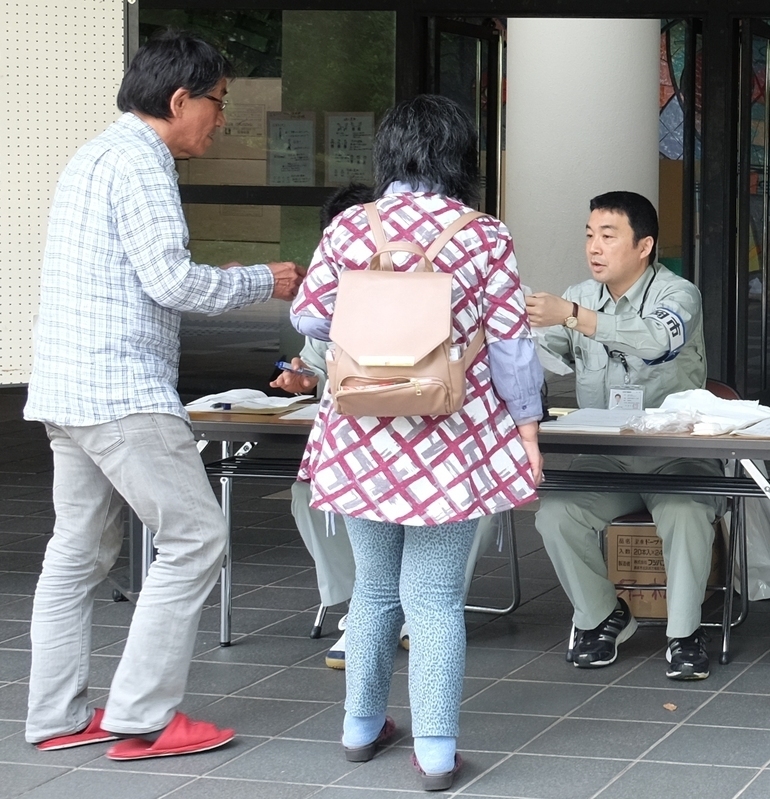 熊本市の拠点避難所に移転する被災者の受付をする小林さんら長岡市職員