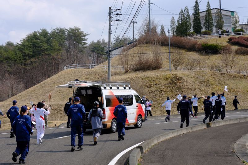 烏賀陽弘道氏撮影。農村部や人口が少ない地域では、大がかりな宣伝カーはなく、一部スタッフと警備の警察官に囲まれてリレーは進む