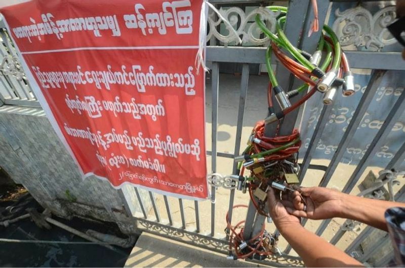 国軍に指名された行政官がオフィスに入らないよう、行政事務所の門に鍵をかける住民（ヤンゴン、２日、写真は現地から筆者が入手）