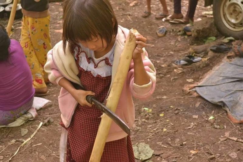 テント作りを手伝う少女（ミャンマー東部シャン州のジャングル、現地からの提供写真）