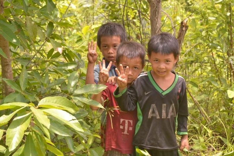 避難先のジャングルで、国軍に抗議し民主化を求める３本指のサインをする子どもたち（現地からの芸鏡写真）