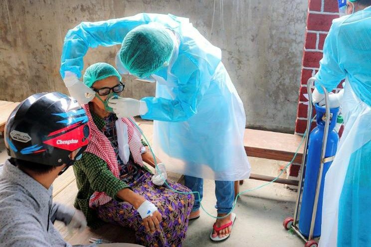 ミャンマー北西部で、感染者に酸素マスクを装着するボランティア