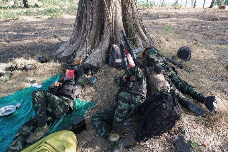 前線の木陰で休む国民防衛隊（PDF）の隊員たち＝2021年12月