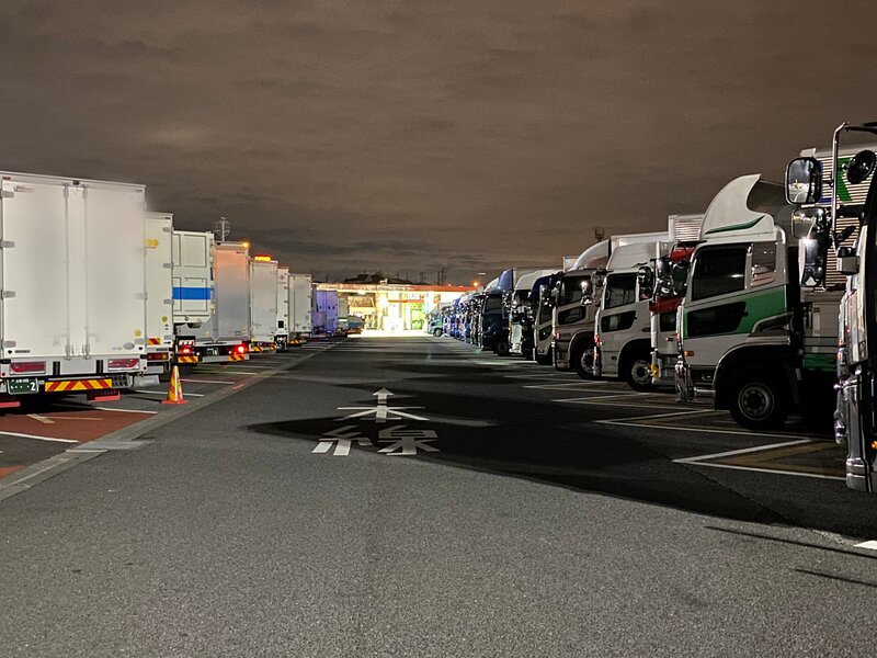 夜になるとサービスエリアには全国各地から他県ナンバーを引っ提げたトラックが駐車マスを取り合う（筆者撮影）