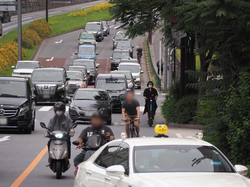 様々な車両が追い抜き・追い越す都内の道路。電動スクーターに乗る筆者