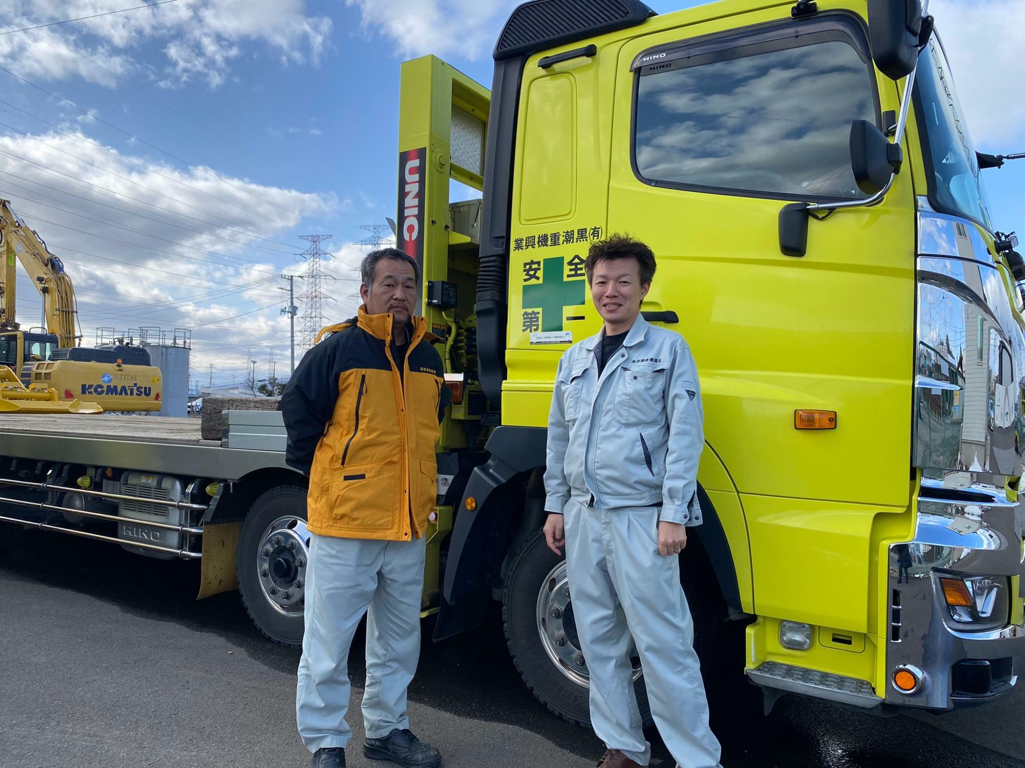 自社のトラックの前に立つ曽根さんと菅原社長（筆者撮影）