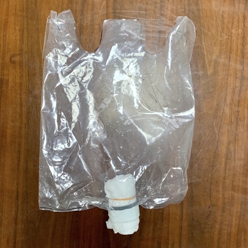 手さげ付きポリ袋の底に、水漏れしないようにホルダを取り付け、レーヨン系不織布を丸めて棒状にし差し込む(著者撮影)