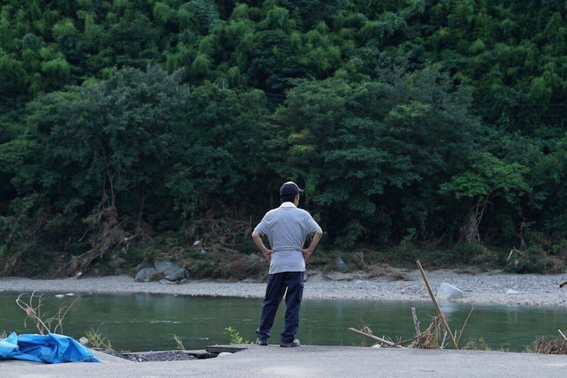 男性はじっと川を見つめていた