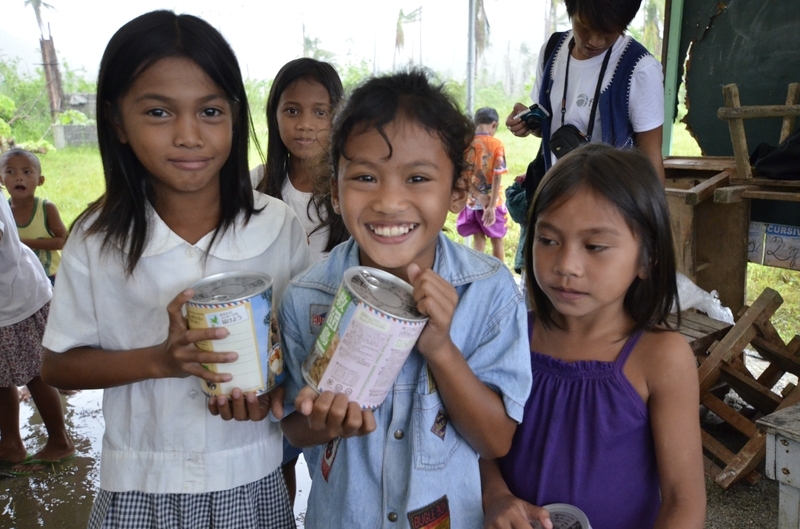 パン・アキモトの缶詰を受け取り喜ぶフィリピンの子どもたち（写真：株式会社パン・アキモト提供）