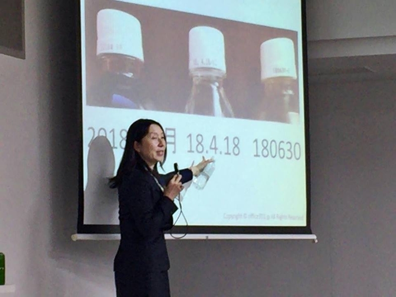 ペットボトルの賞味期限表示は年月日表示から年月表示へと移行している。3ヶ月以上賞味期間があるものは日付表示を省略することでロスを減らすことができる(講演中の筆者。東洋大学で職員撮影)