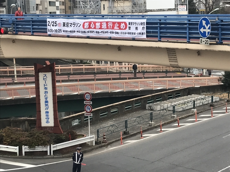 JR飯田橋駅前の交差点には東京マラソンのための交通規制の垂れ幕が掲示されていた（筆者撮影）