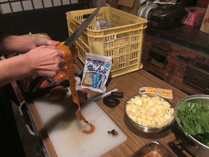 「瀬戸内0円キッチン」の調理風景。熟柿を剥いてサラダにする（筆者撮影）