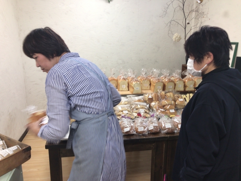 予約したパンを取りに来たお客様（右）に対応する宗高美恵子さん（左）。宗高さんは画家として六本木などの展覧会に絵を出展している（筆者撮影）