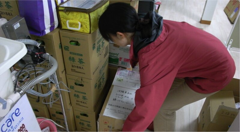 東日本大震災発生の翌月（2011年4月）、神奈川県の企業にまとめて届いた支援物資の仕分け作業をする筆者（知人撮影）