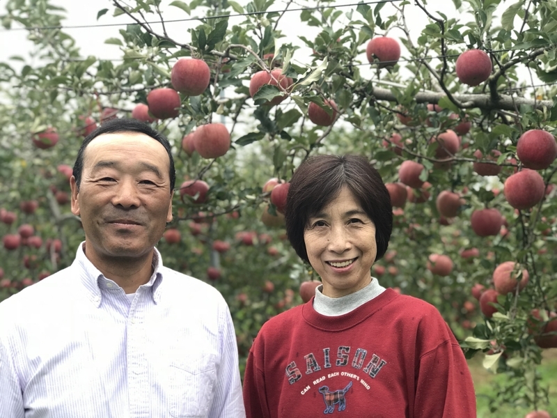 長野県、飯田下伊那りんご部会長でりんご農家の北沢章さん（左）と奥様（森本康雄さん撮影）