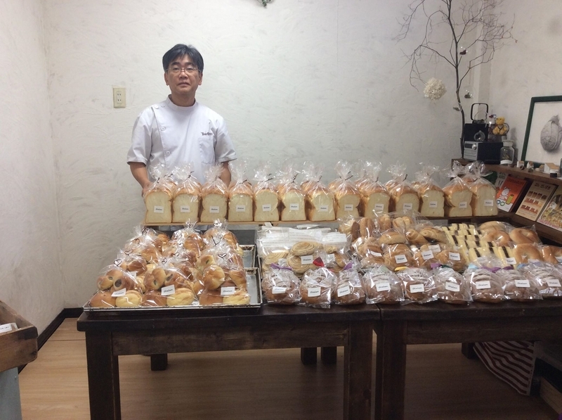 埼玉県川口市の坂巻達也さん。前に並んだパンは全て予約されたもの。このあと全て売り切れた（筆者撮影）