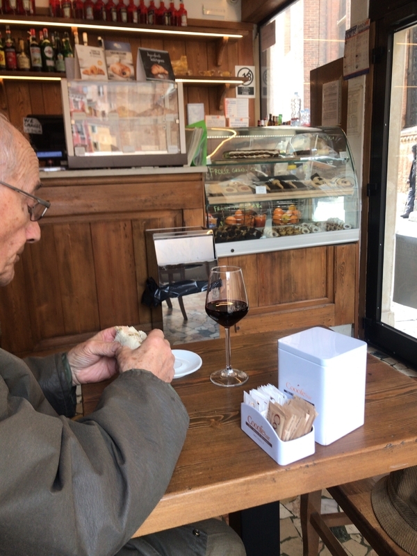 イタリア・ベネツィアのカフェでサンドウィッチと赤ワインを楽しむ男性（筆者撮影）