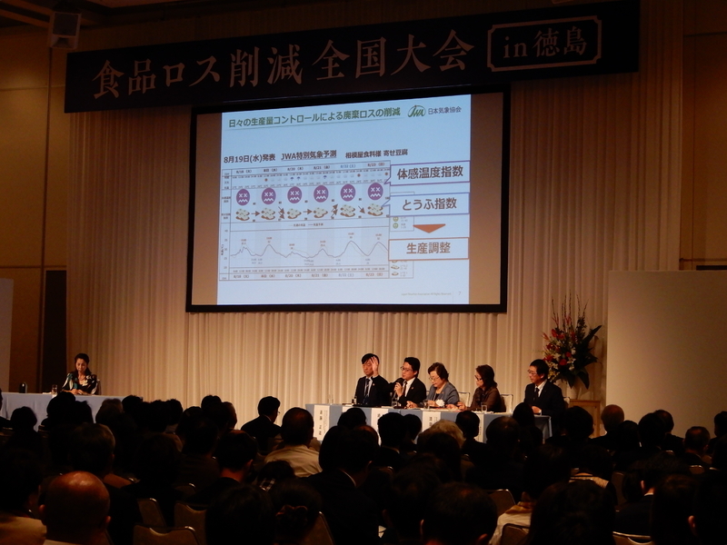 5名のパネリストと1名のコーディネーターで行われたトークセッション。日本気象協会の本間基寛氏が、気象データを活用しての食品ロス削減を説明している（筆者撮影）