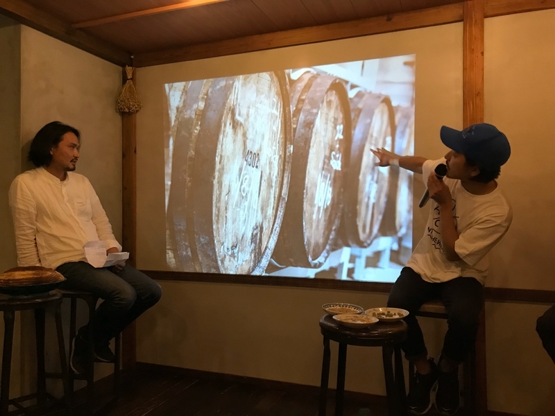 ウィスキーやワインの木樽（バレル）でビールを数ヶ月寝かせて作るバレルエイジのビールについて説明する佐藤さん（筆者撮影）