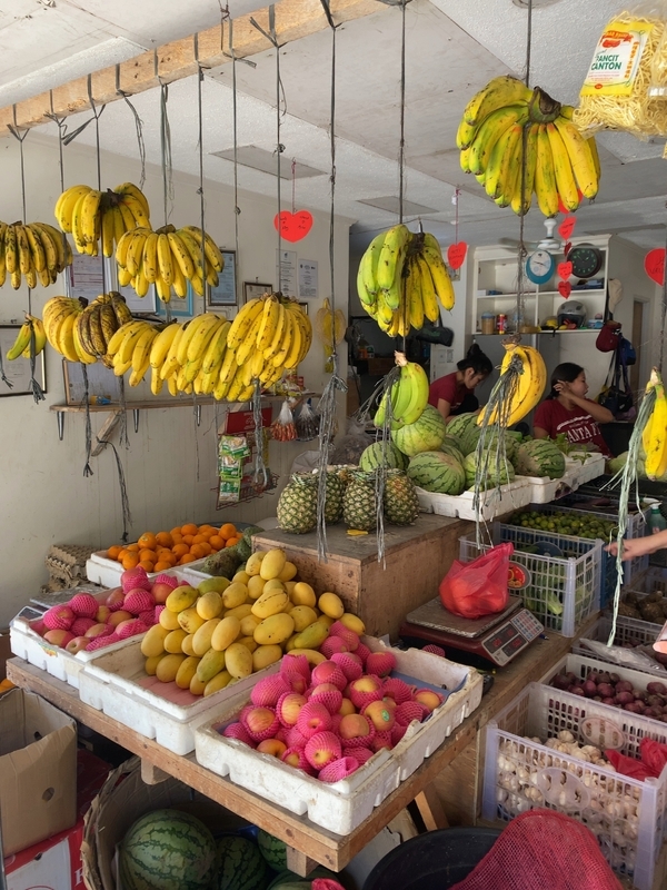フィリピンの果物店で軒先からつるされて売られるバナナ（筆者撮影）