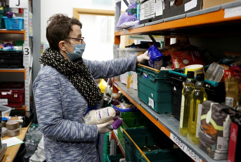A volunteer at the North Enfield Foodbank Charity packs a bag of groceries and other household items for distribution in Enfield as the spread of coronavirus disease (COVID-19) continues in London, Britain March 24, 2020. REUTERS/John Sibley (Britain)