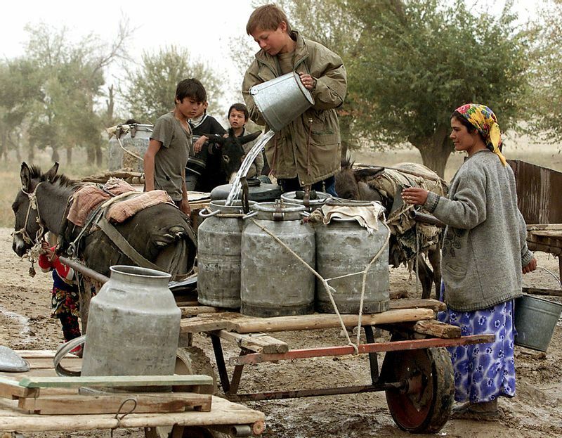 家から4km離れたところで水を汲む家族：A Tajik family fills up water cans, 4kms from their home, in the village of Dgharteba, some 120kms from Dushanbe